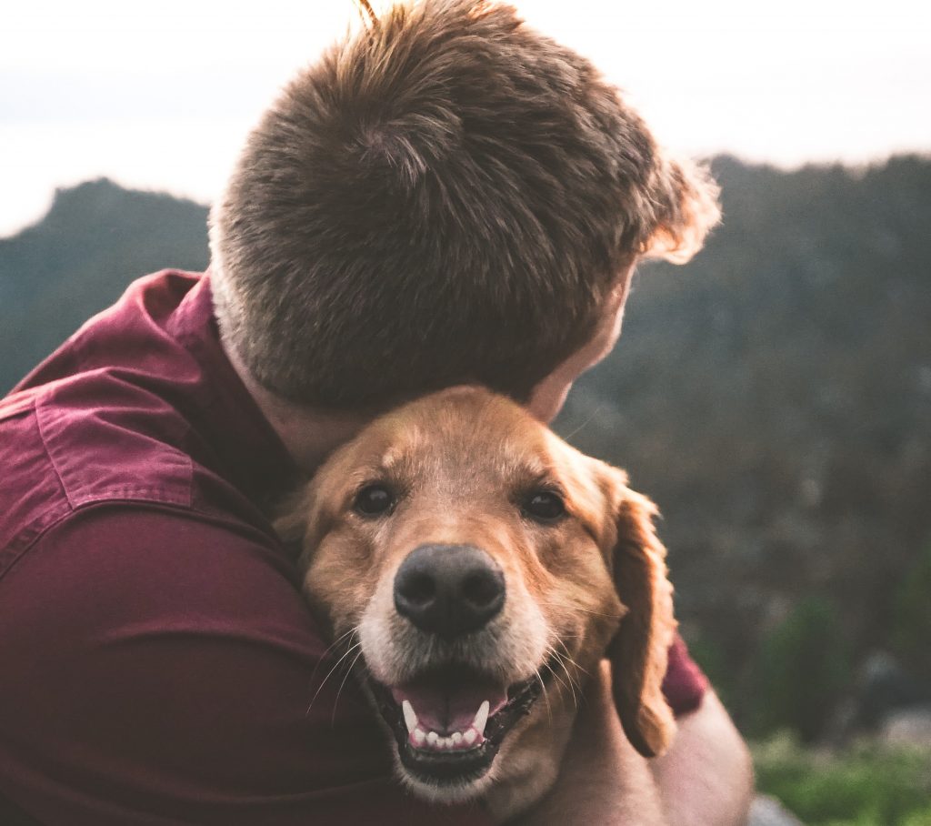 Hombre abrazando a su perro
